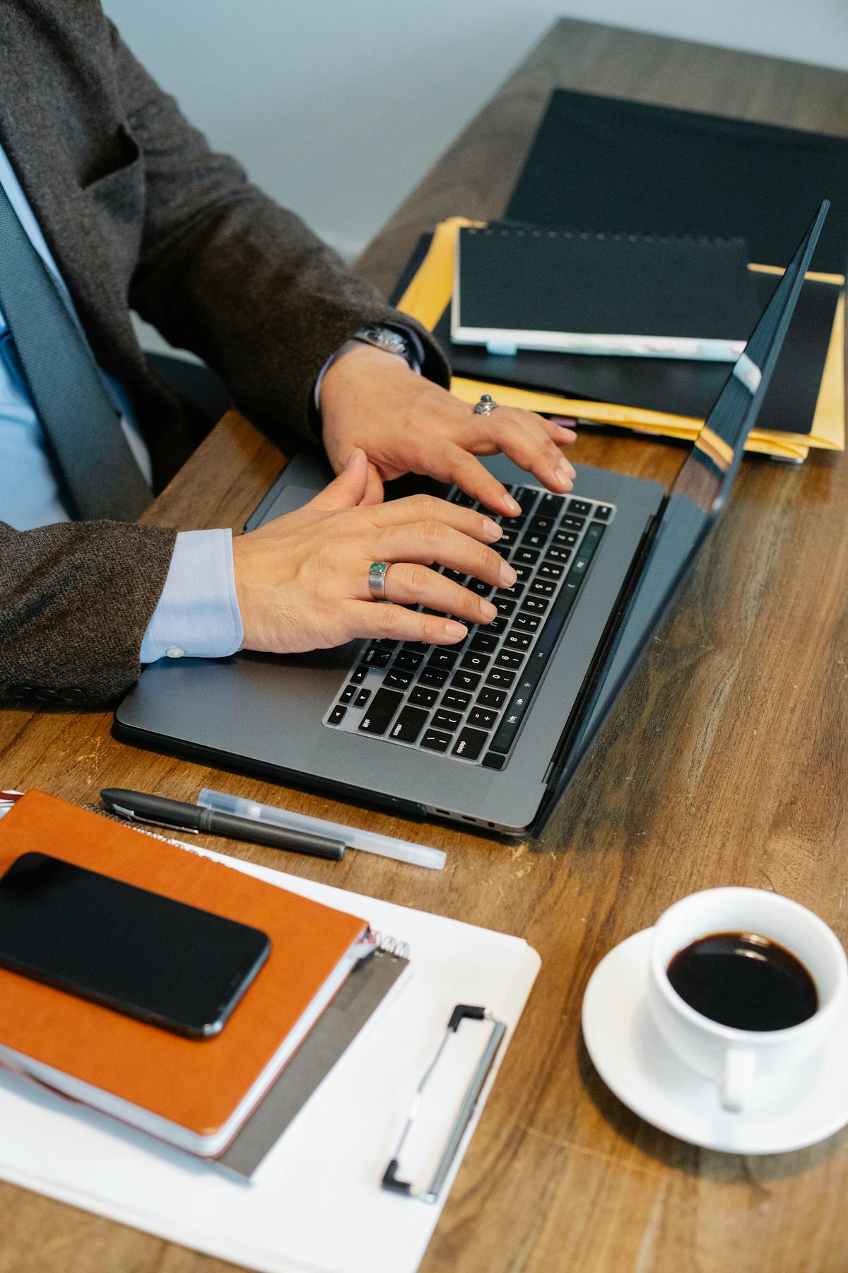 Laptop and paper documents on a desk representing manual office operations